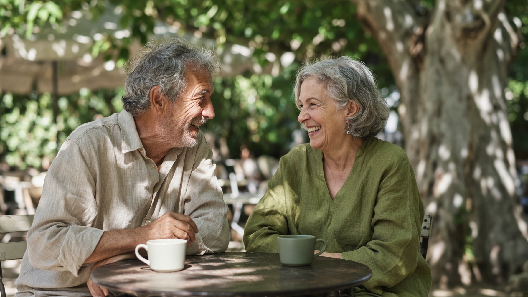 Friends talking closely at an outdoor cafe table